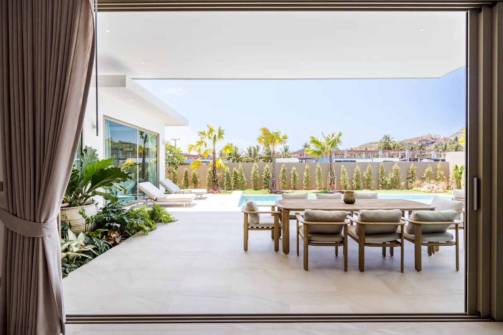 Sliding doors open from a JG living room onto the covered terrace